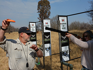 Coach demonstrating a clay launch beside a guest