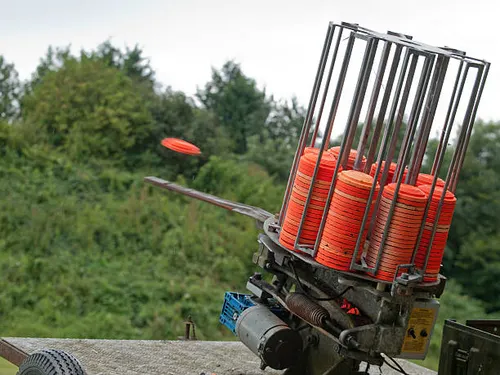 A clay pigeon ejecting from a trap machine